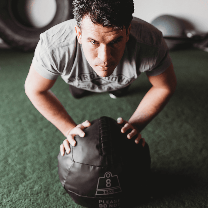 Medicine ball used by man for pushups.